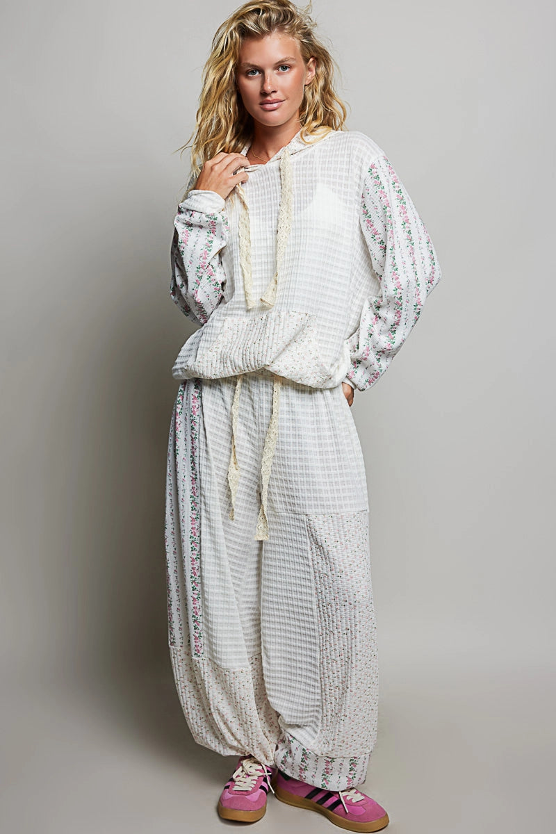 woman wearing matching white waffle knit top and bottom on plain background