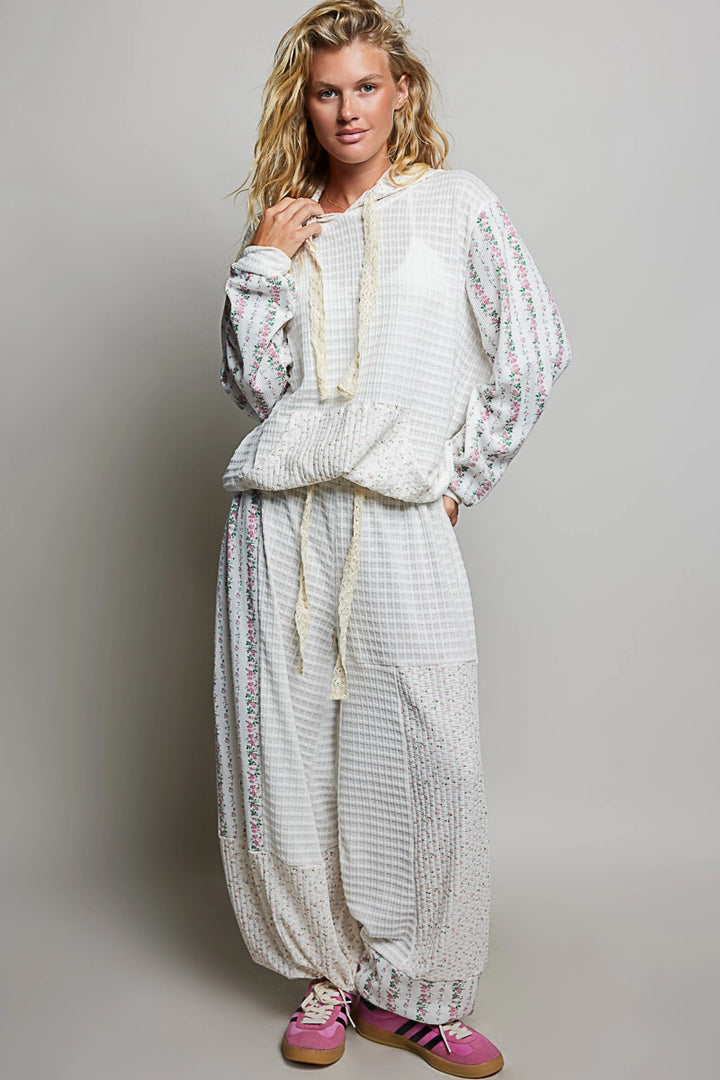 woman wearing matching white waffle knit top and bottom on plain background