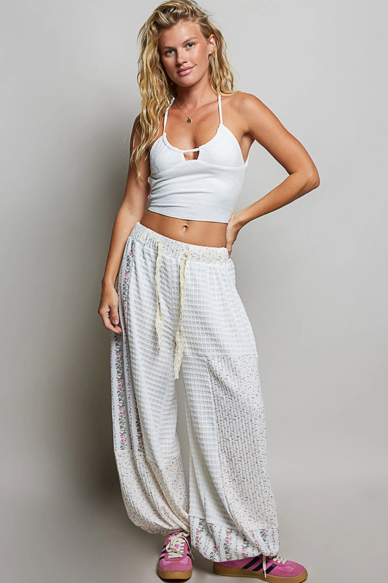 person wearing white waffle knit pants with white top on plain background