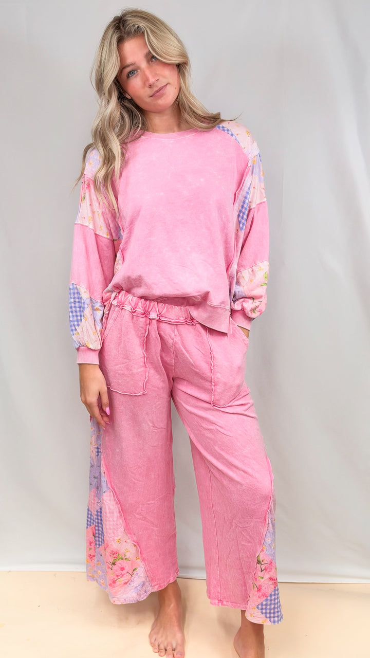 Woman wearing matching pink, patchwork top and bottom on plain background