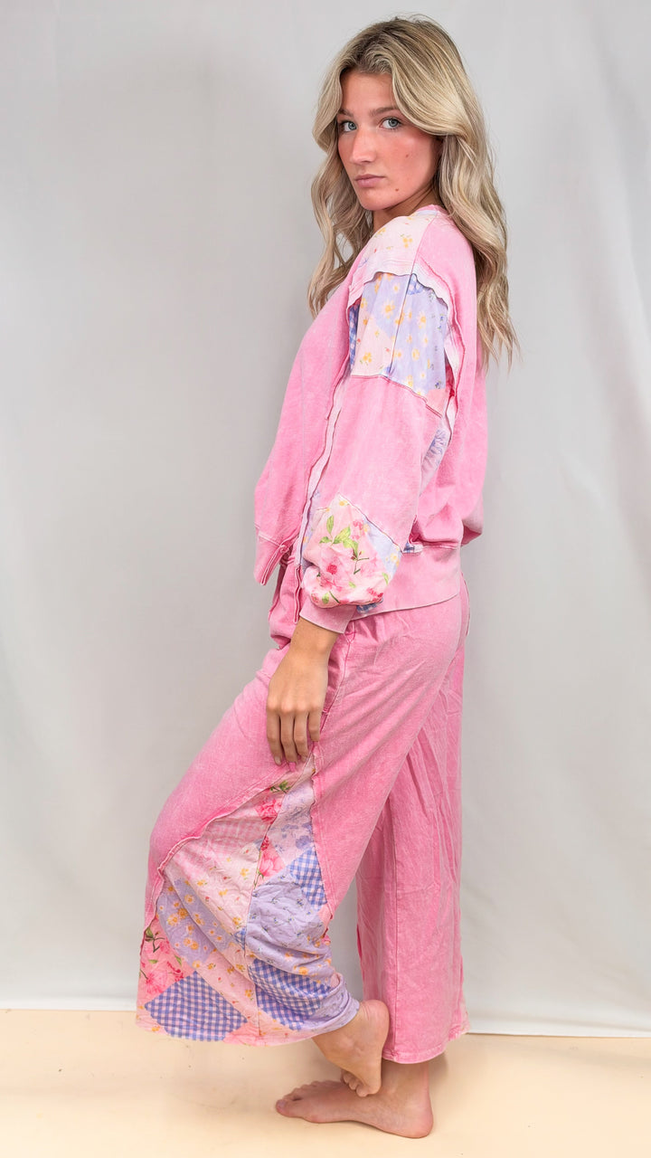 Woman wearing matching pink, patchwork top and bottom on plain background