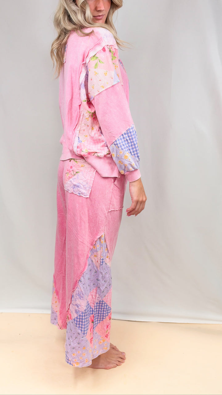 Woman wearing matching pink, patchwork top and bottom on plain background