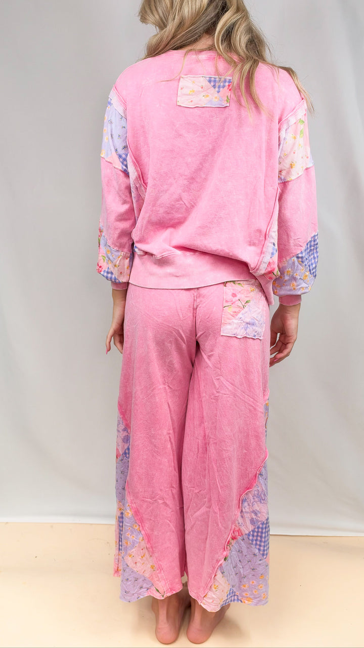 Woman shown from back wearing matching pink, patchwork top and bottom on plain background