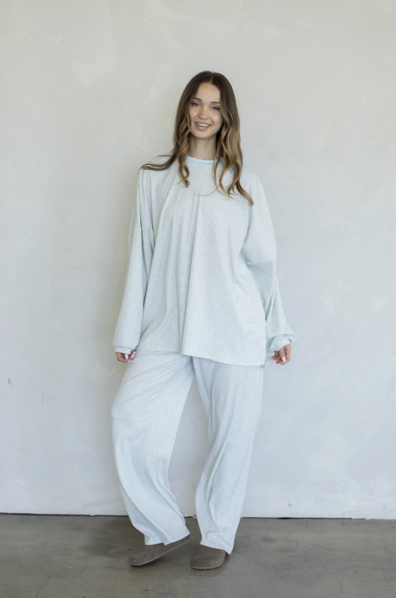 Woman wearing baby blue matching set on plain background