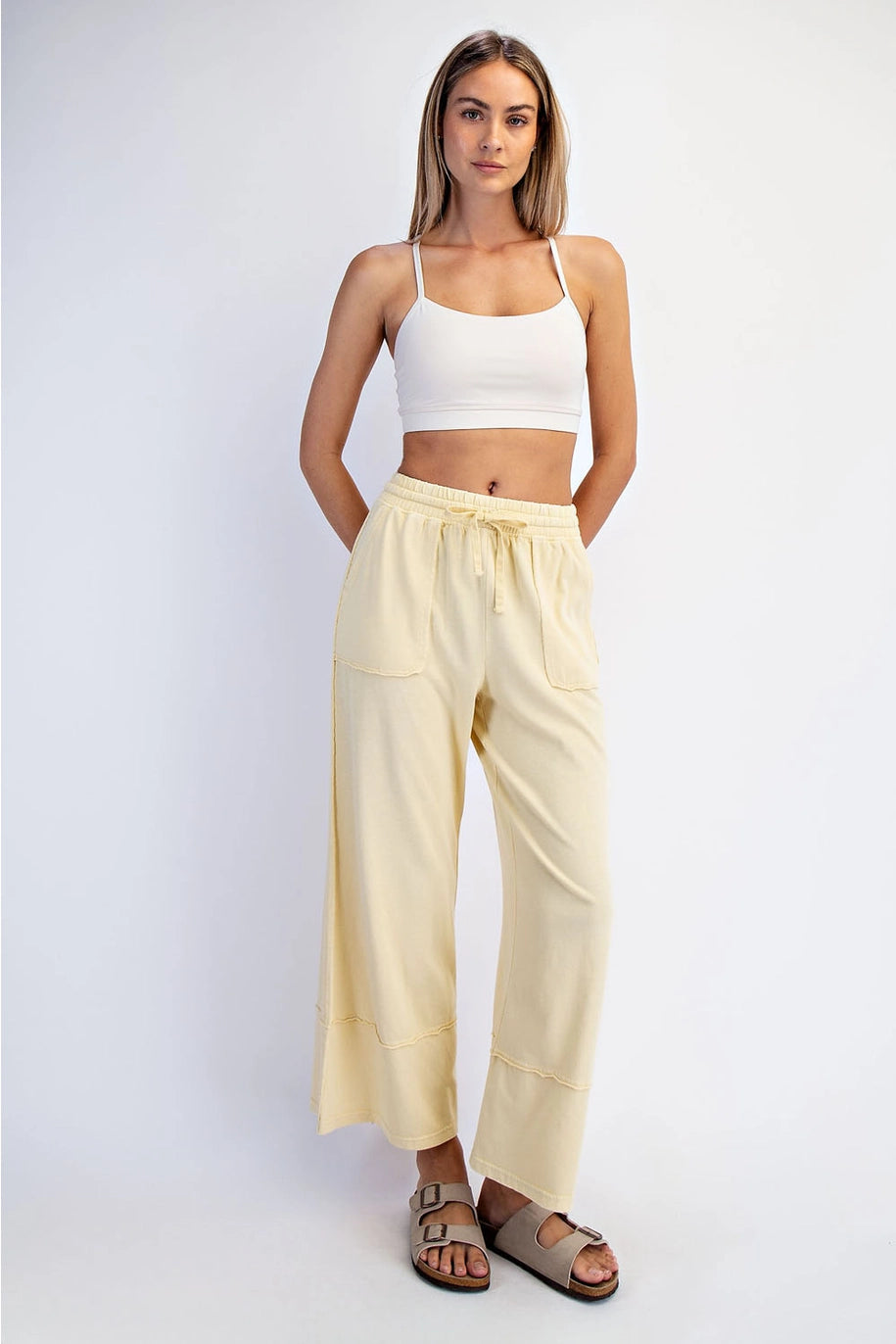 Woman wearing a white top and beige pants on a white background