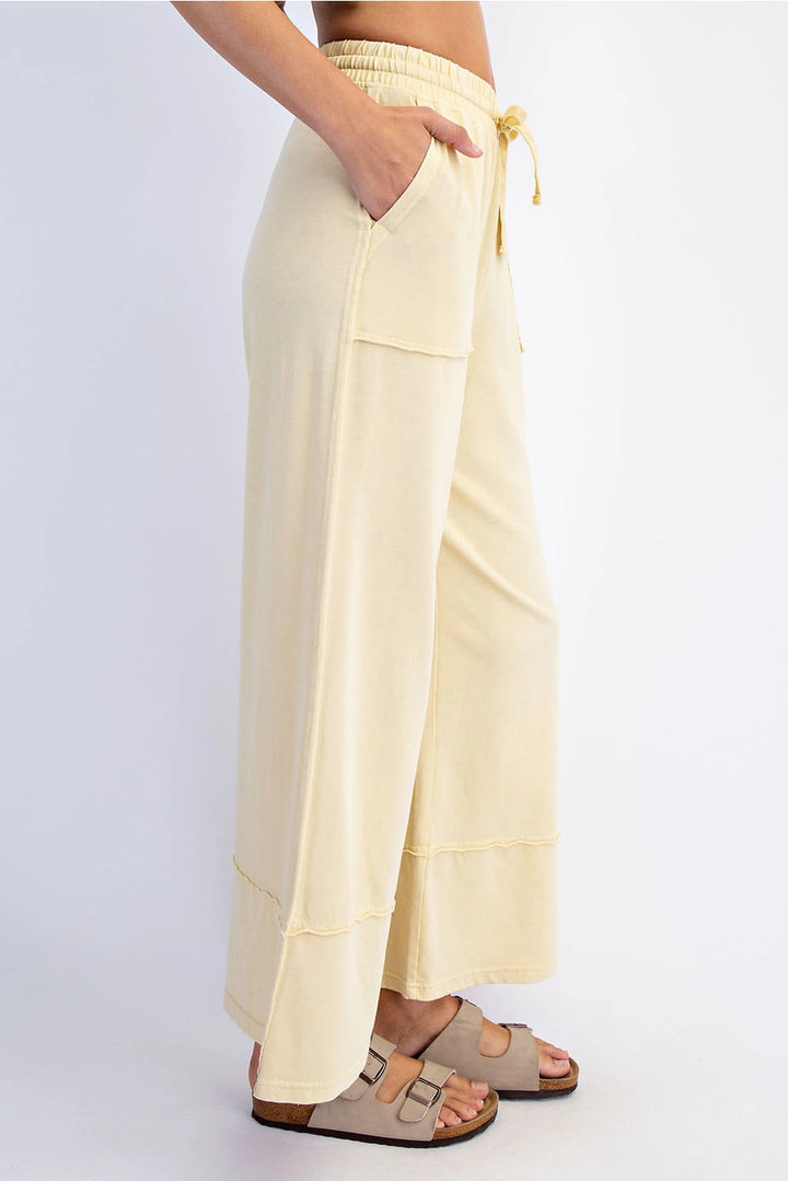 Beige wide-leg pants worn by a person on a white background