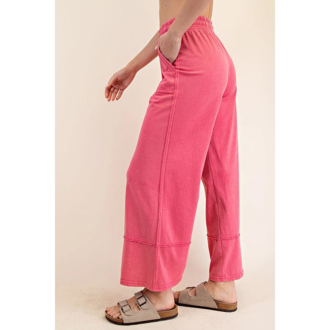 Person wearing bright pink pants on a beige background