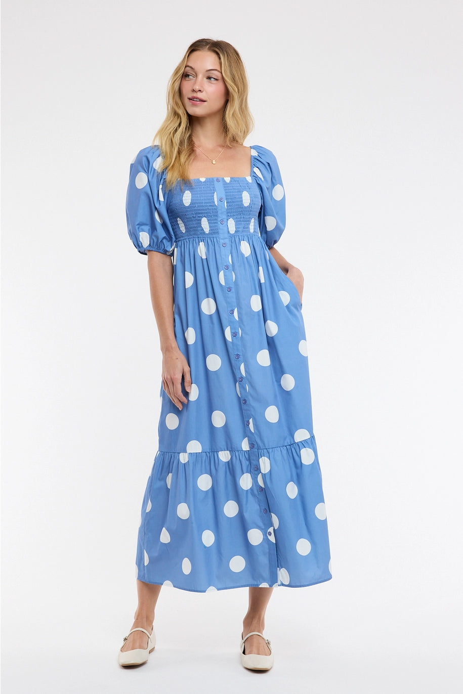 Woman wearing blue polka dot dress on plain background