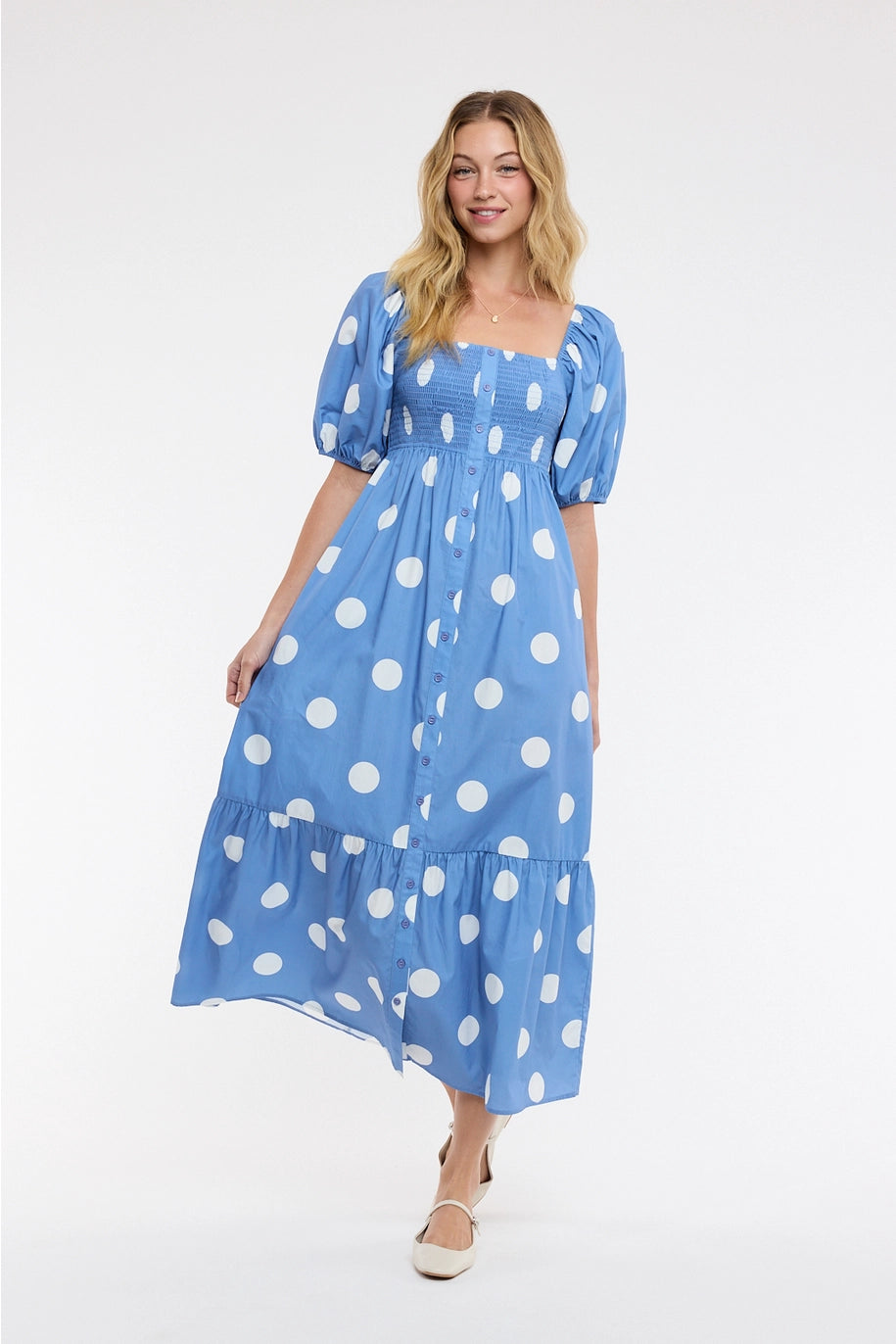 Woman wearing blue polka dot dress on plain background