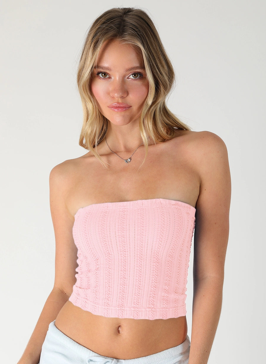 Woman wearing pink tube top on plain background