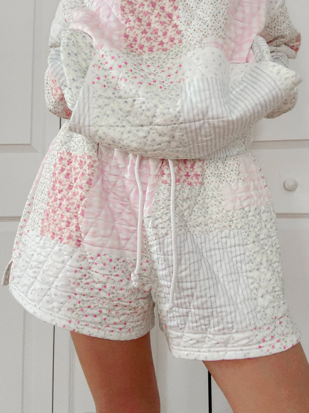 Person wearing quilted shorts on plain background