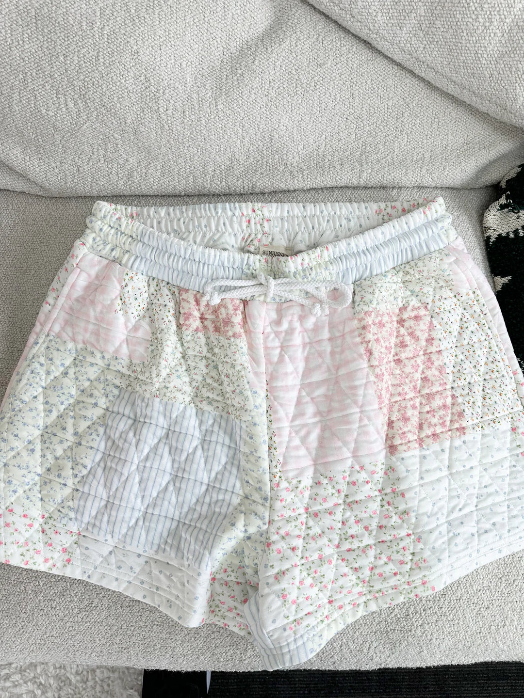 Quilted shorts lying on plain background