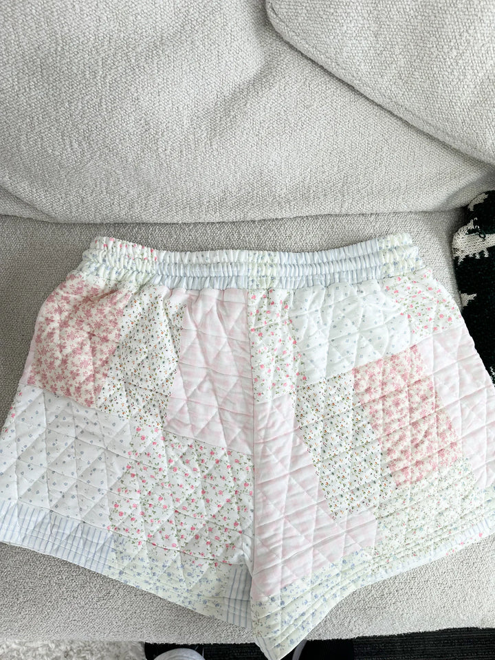 Back of quilted shorts lying on plain background