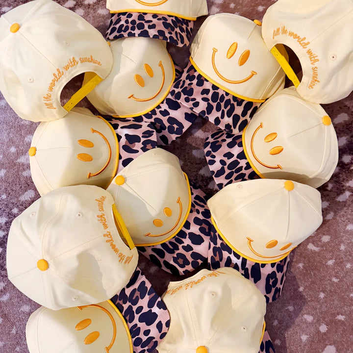 White hats with smiley faces and text on a leopard print background