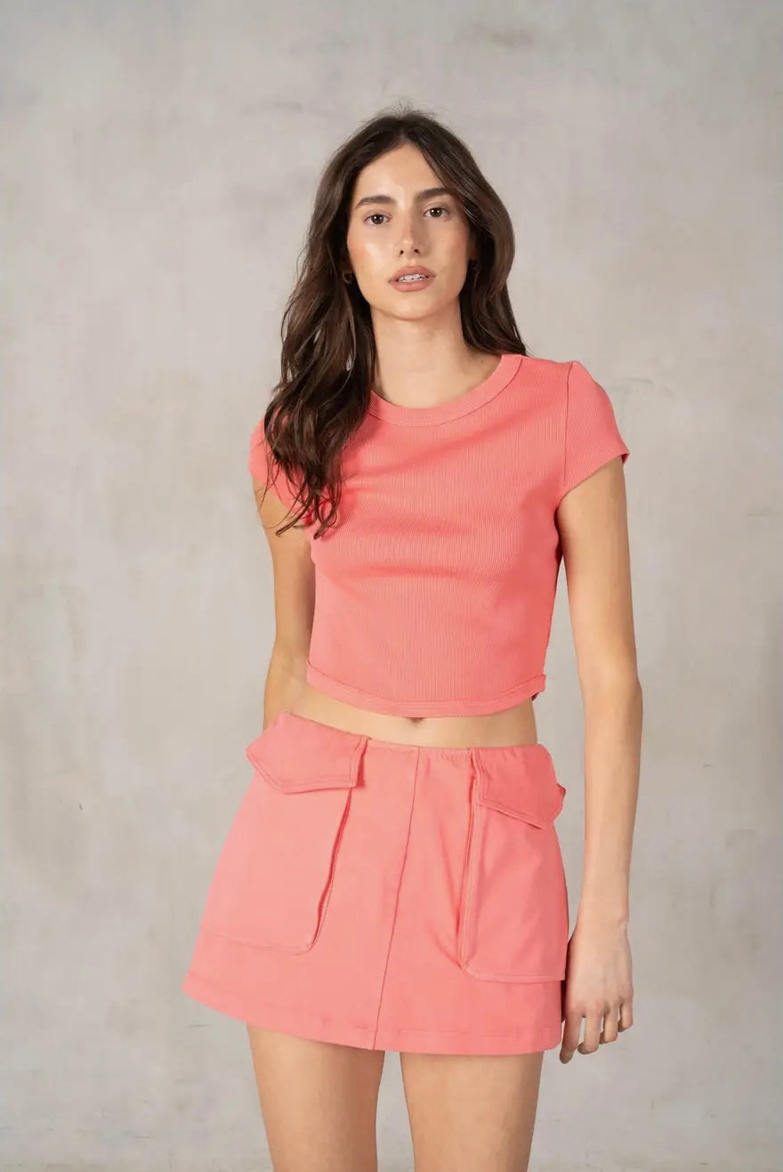 Woman wearing a pink outfit against a plain background