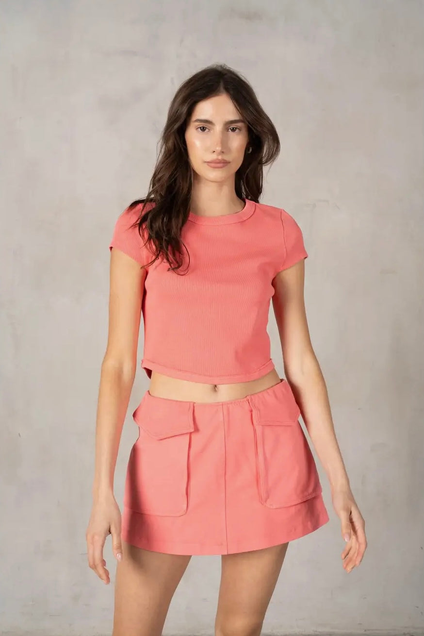 Woman wearing a pink outfit against a plain background