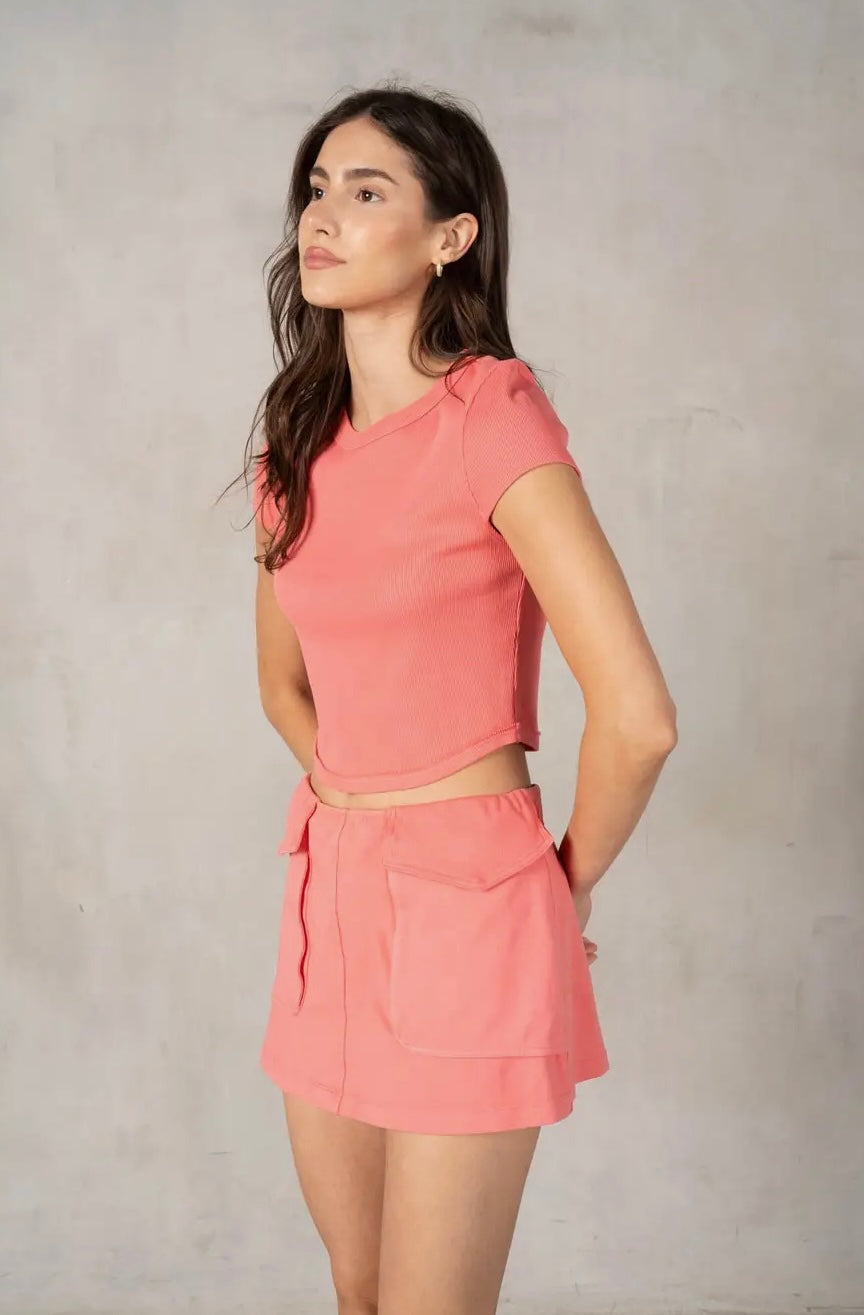 Woman wearing a pink outfit against a plain background