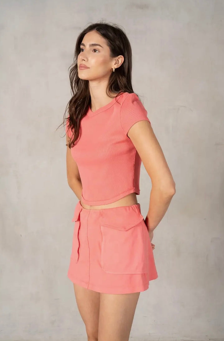 Woman wearing a pink outfit against a plain background