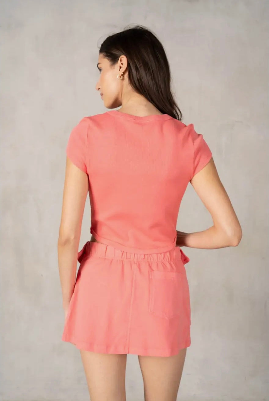 Woman wearing a pink dress against a plain background