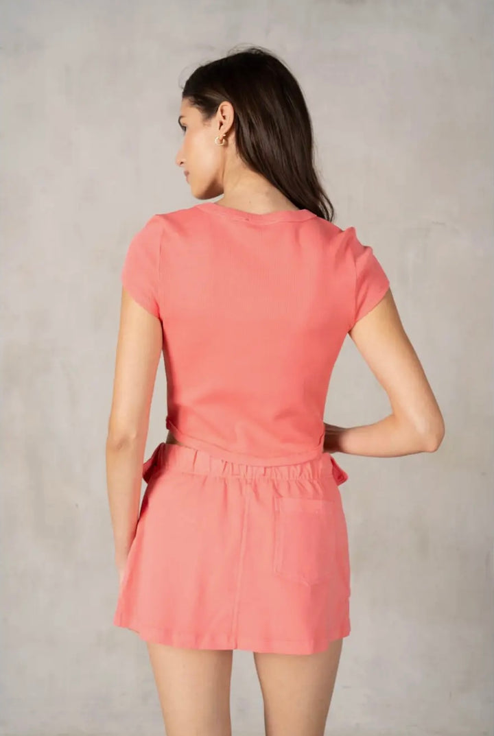 Woman wearing a pink dress against a plain background