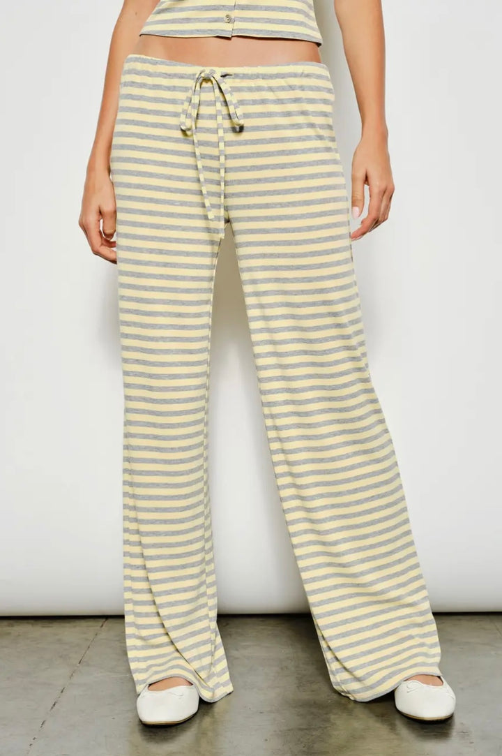 Person wearing yellow and white striped pants against a plain background
