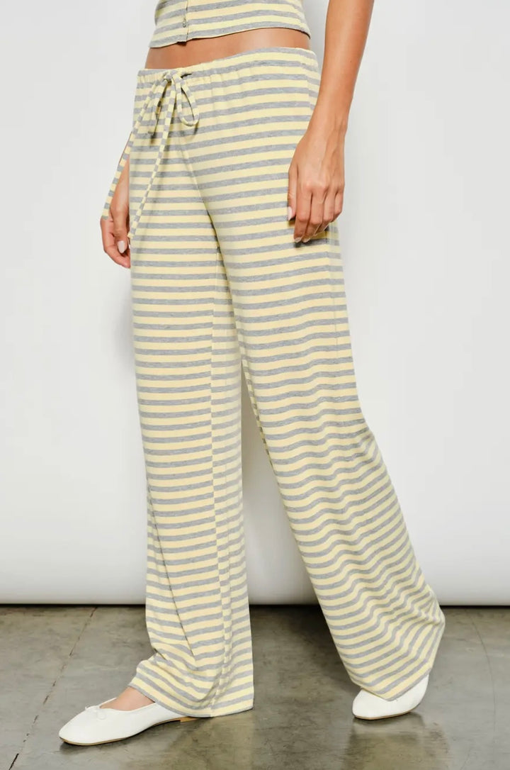 Person wearing yellow and white striped pants with a plain background