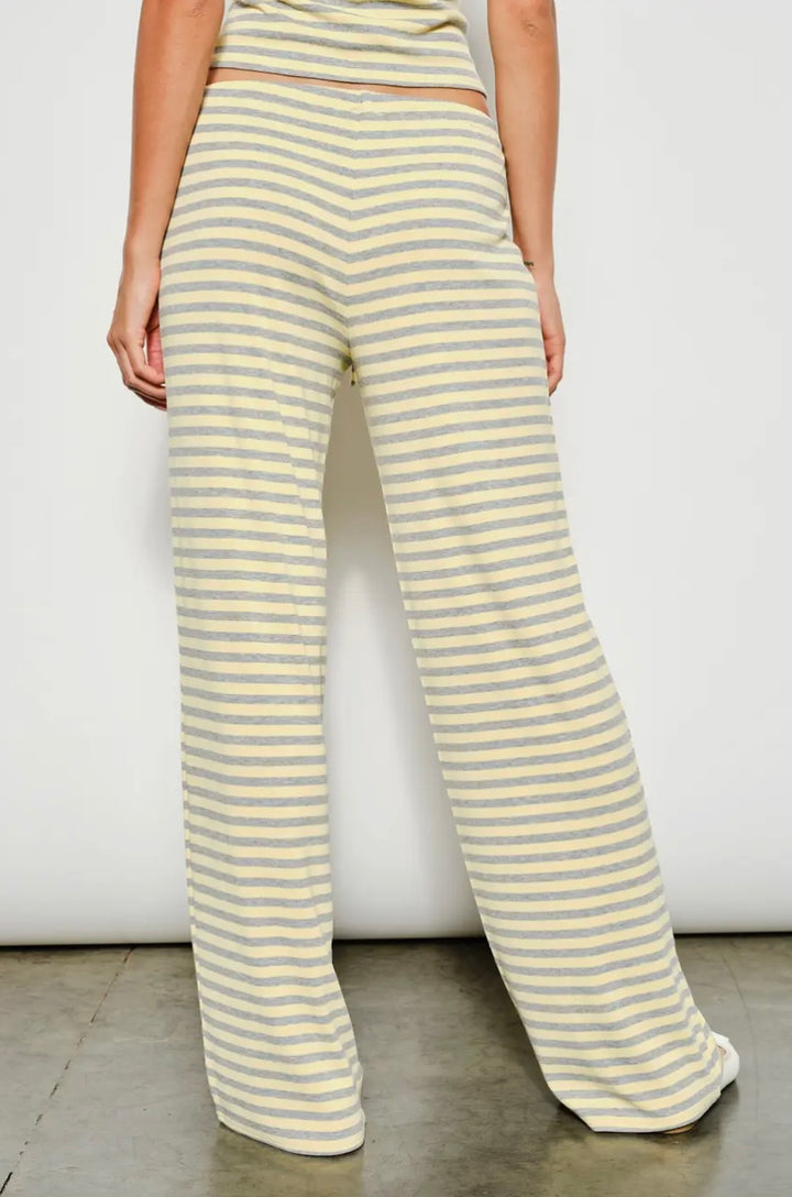 Person wearing yellow and white striped pants against a plain background