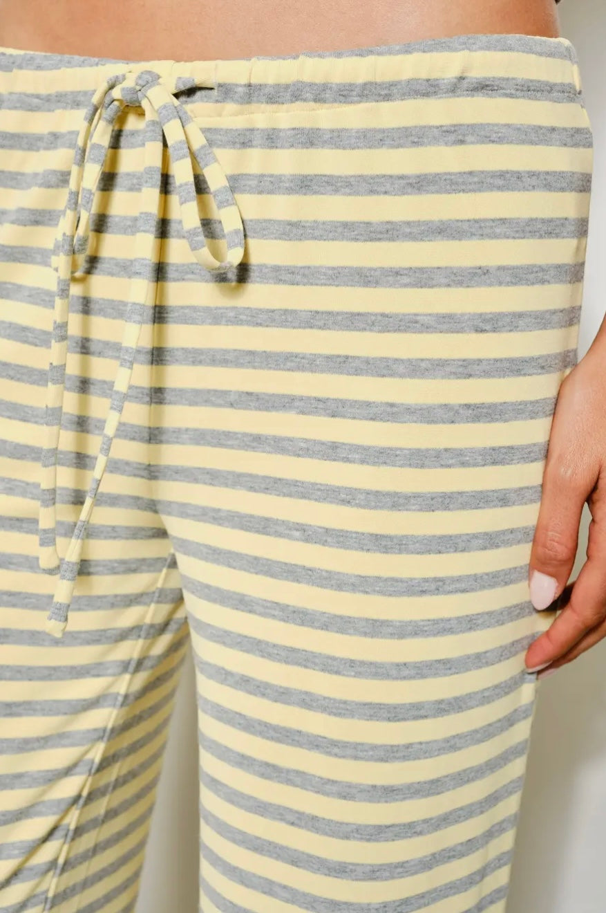 Yellow and gray striped pants with a drawstring waist on a neutral background