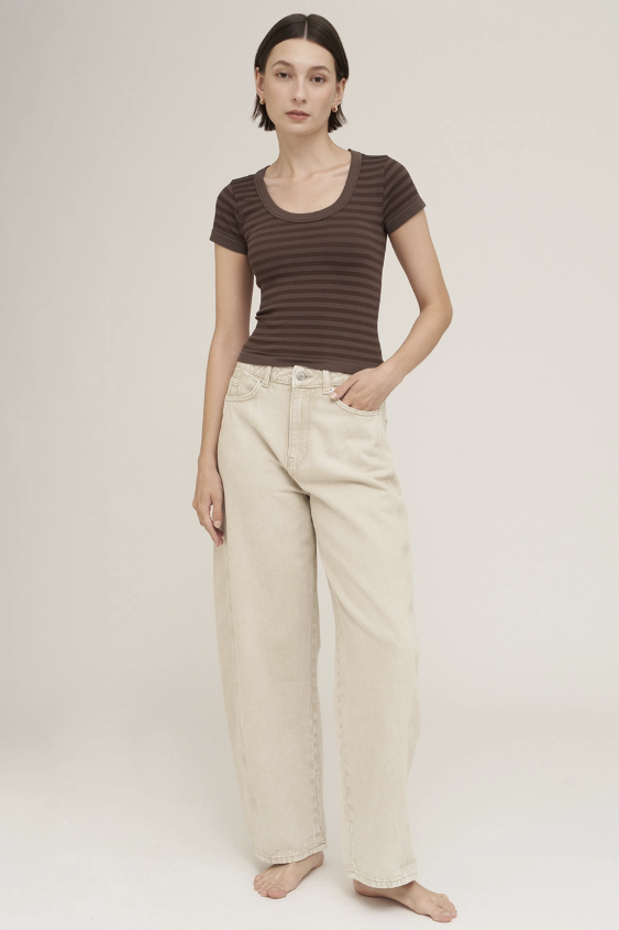 Woman wearing brown striped scoop neck tee with khaki pants on white background