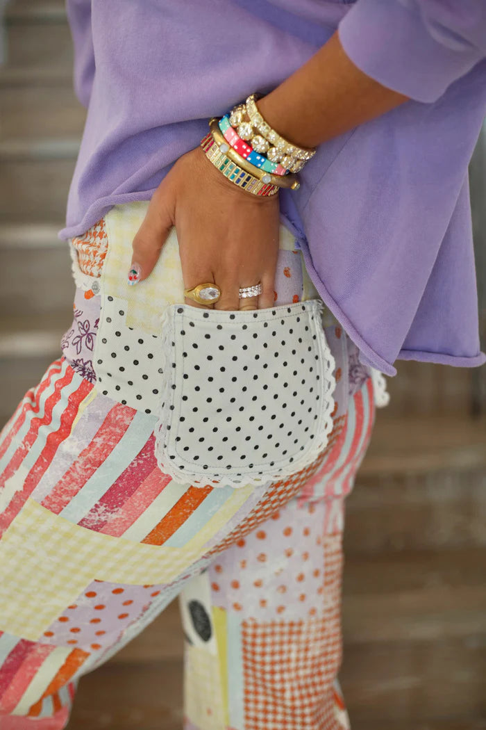 Person wearing colorful pants with a patterned top and accessories.