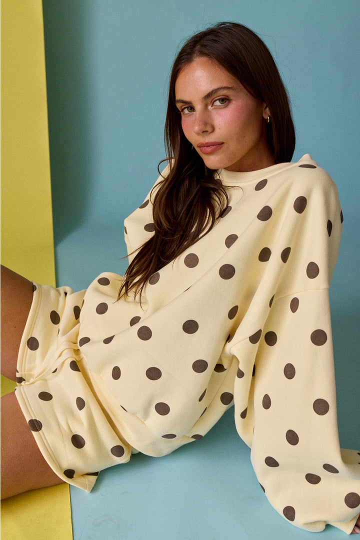 woman wearing yellow with brown polka dot matching set on colorful background