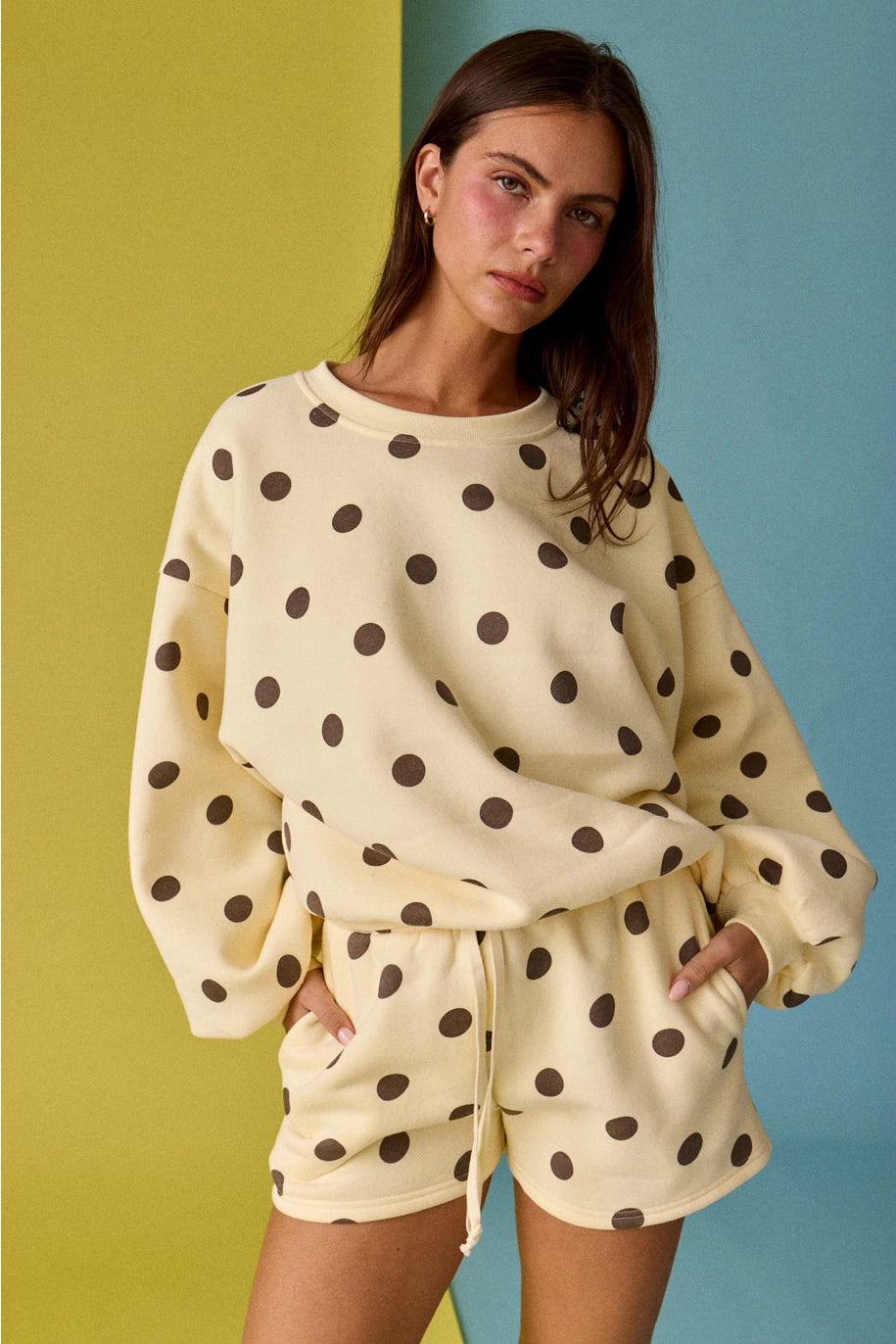 Woman wearing a polka dot outfit against a colorful background