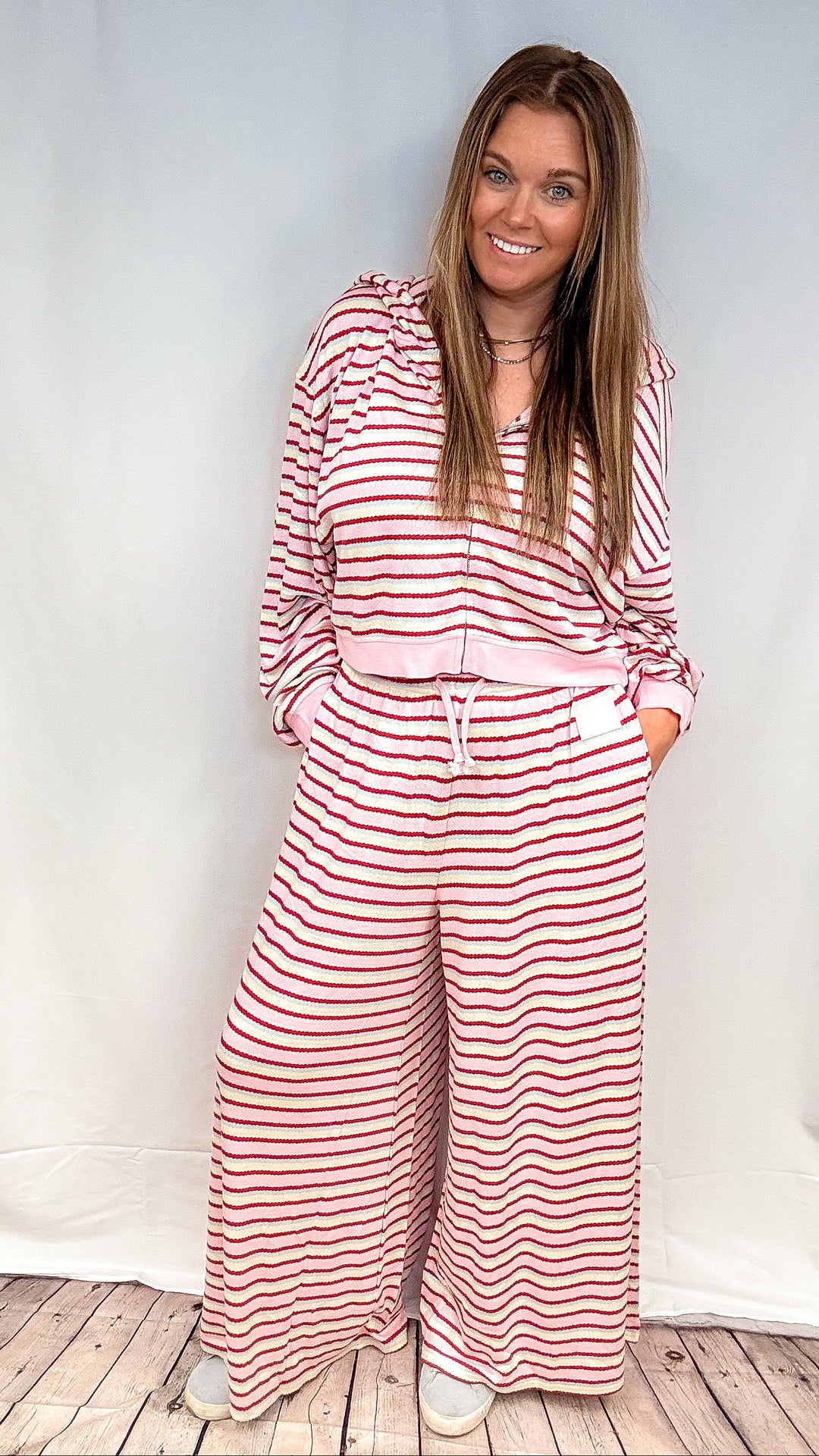 Woman wearing pink, maroon, yellow and blue matching stripe set on white background