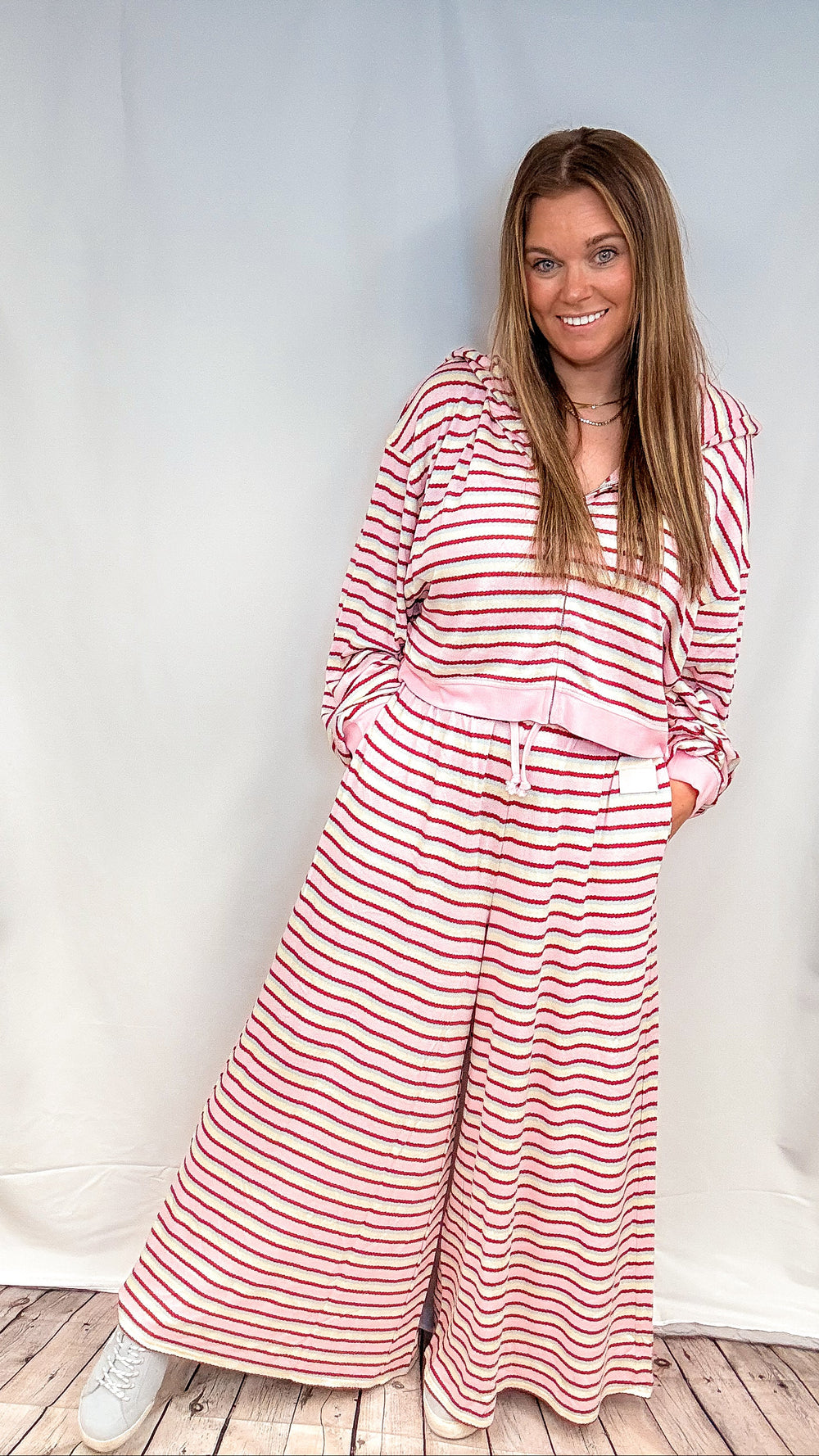 Woman wearing matching pink, maroon, yellow and blue stripe set on white background