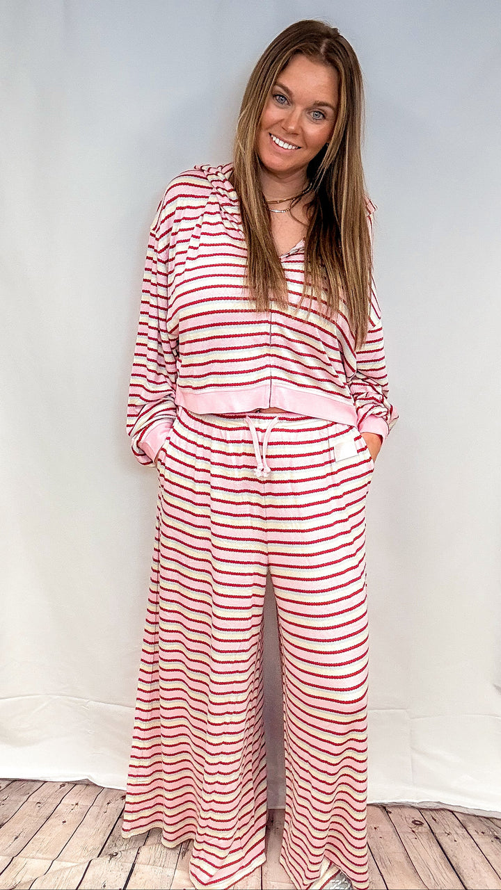 Woman wearing matching pink, maroon, yellow and blue stripe set on white background