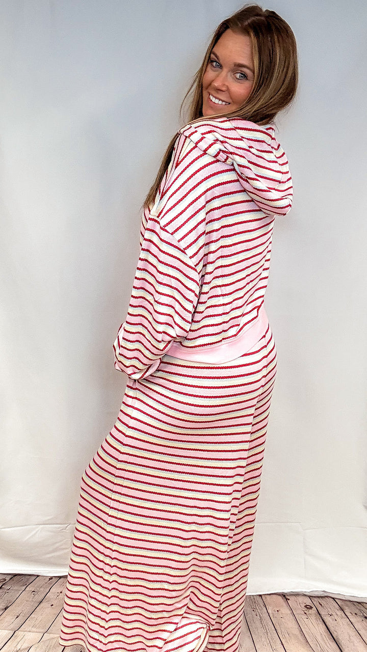 Woman wearing matching pink, maroon, yellow and blue stripe set on white background