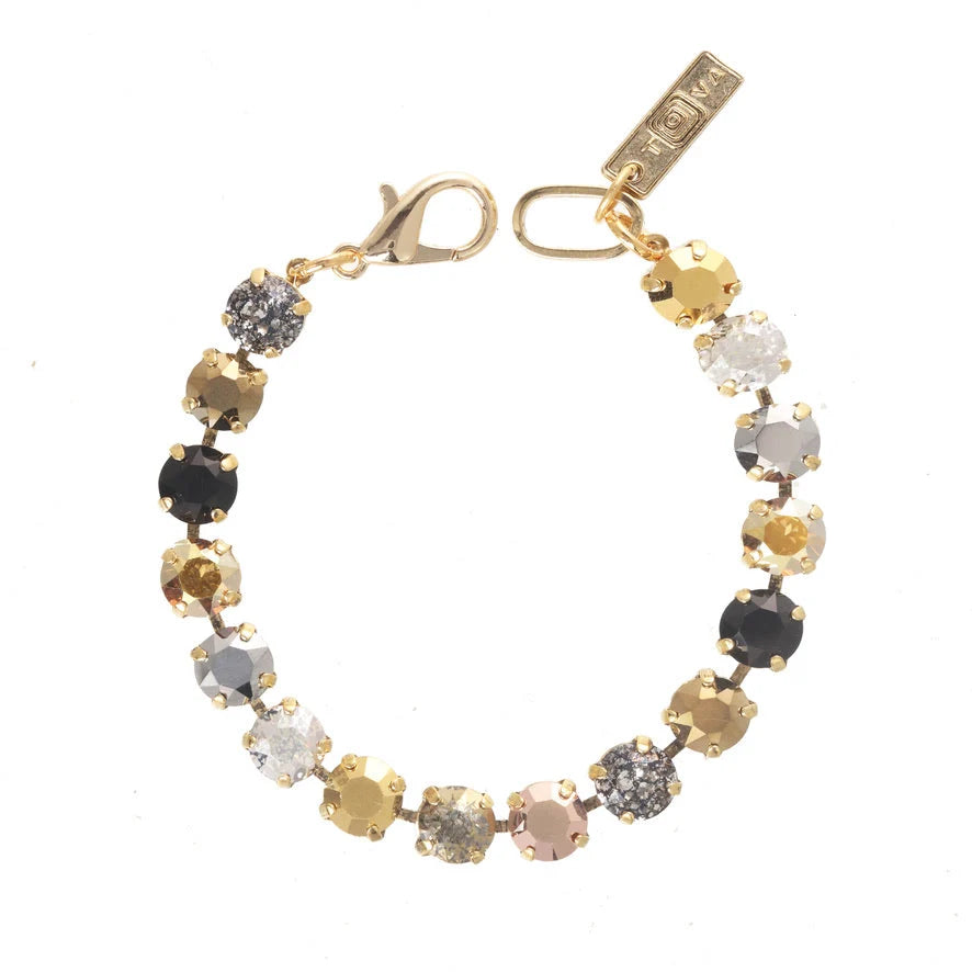 Crystal bracelet with black, silver and gold crystals and gold clasp on plain background