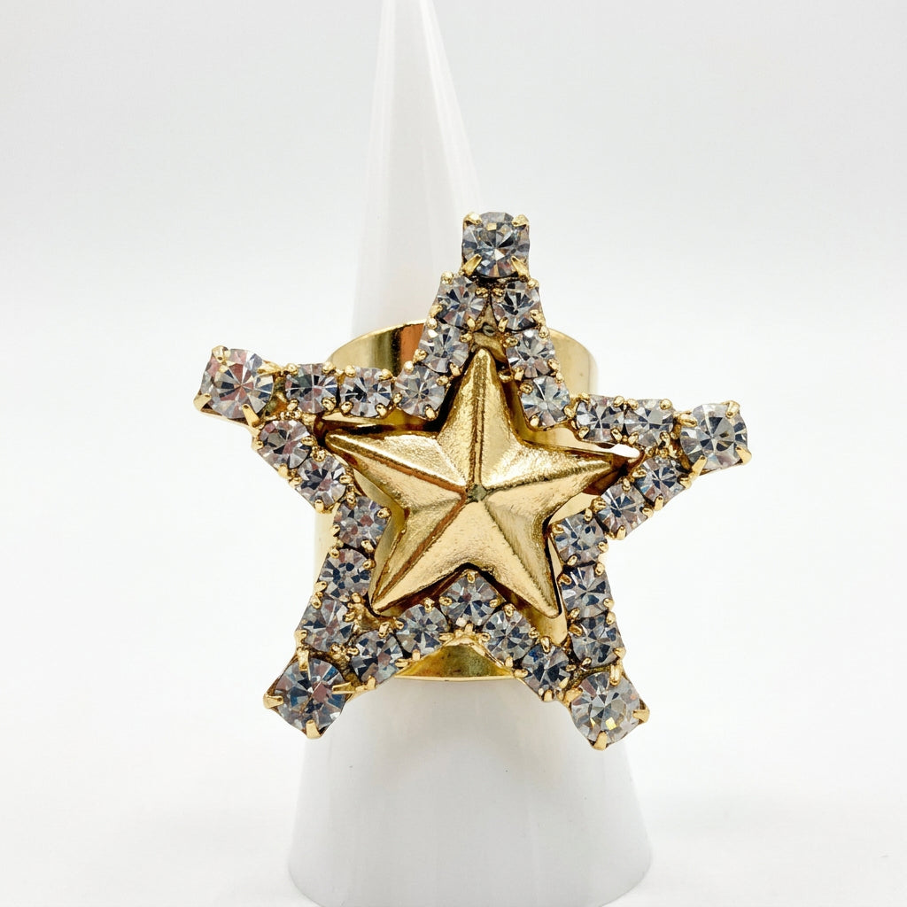 Gol star ring with clear crystals along the outter edge on plain bacground