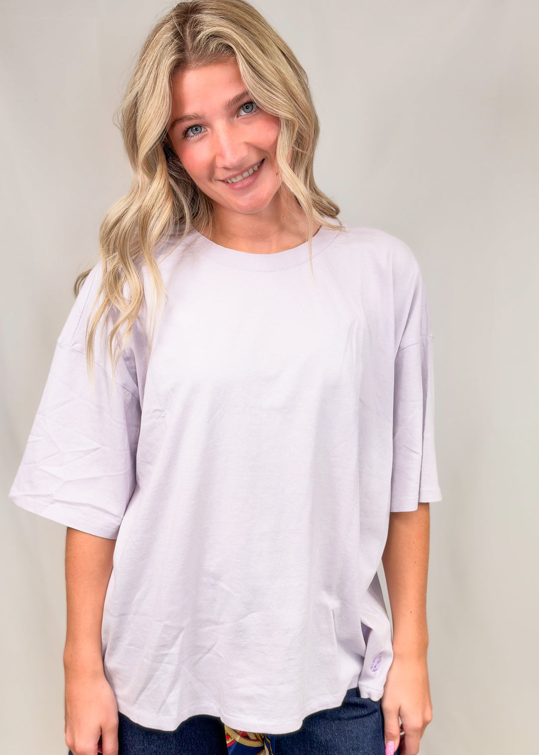 Woman wearing purple tee on plain background