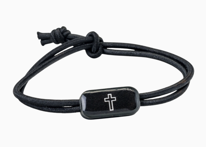 Black cord bracelet with a silver cross charm on a white background