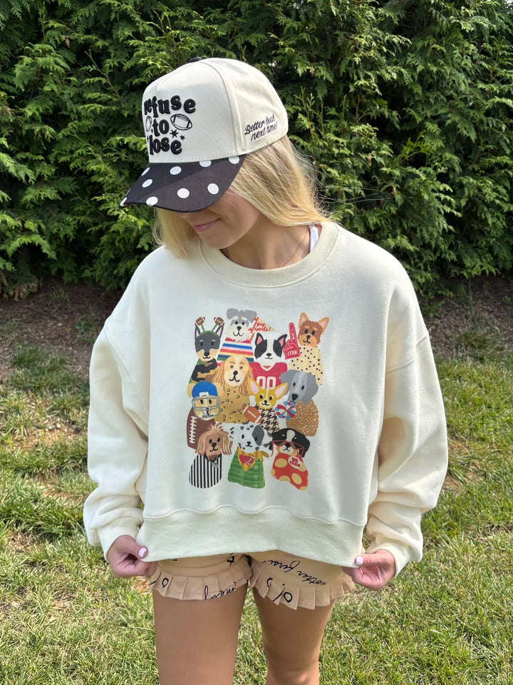 Woman wearing cropped sweatshirt with football theme dogs on front standing outside.