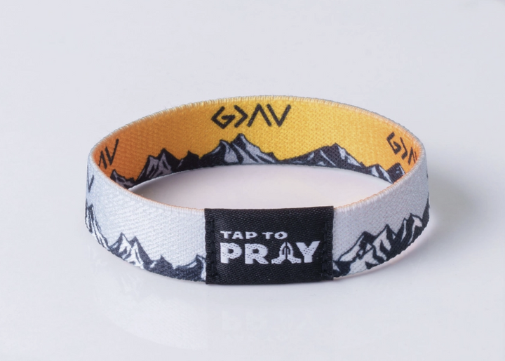 Tap To Pray bracelet featuring god is greater than the highs and lows symbol with sunset and mountains on white background