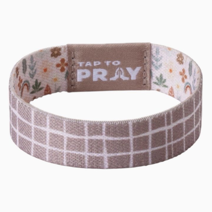 Tap to pray bracelet with symbols and plaid on plain background