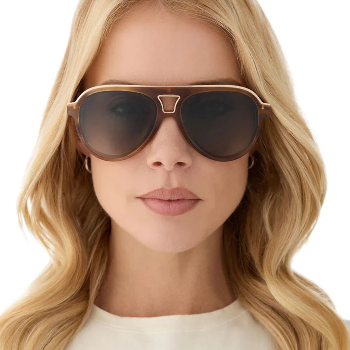 Woman wearing a pair of sunglasses with a neutral background