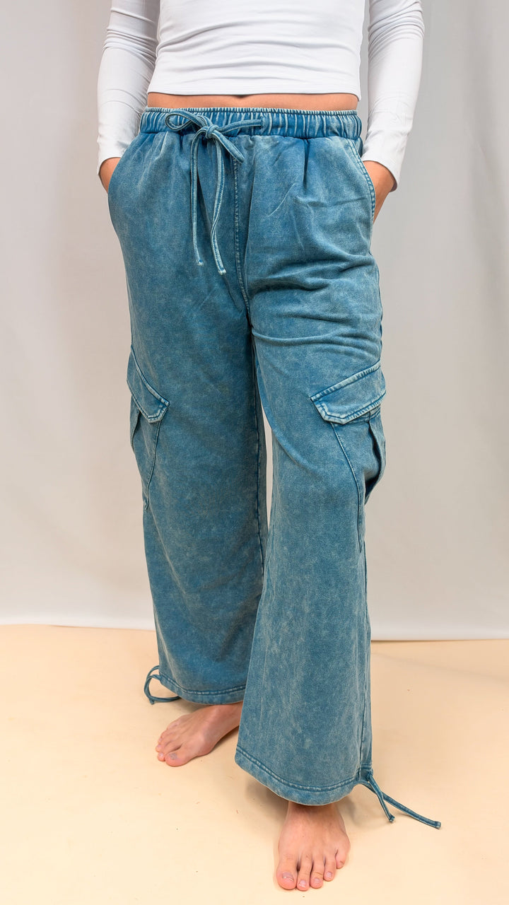 Woman wearing teal blue pants on plain background