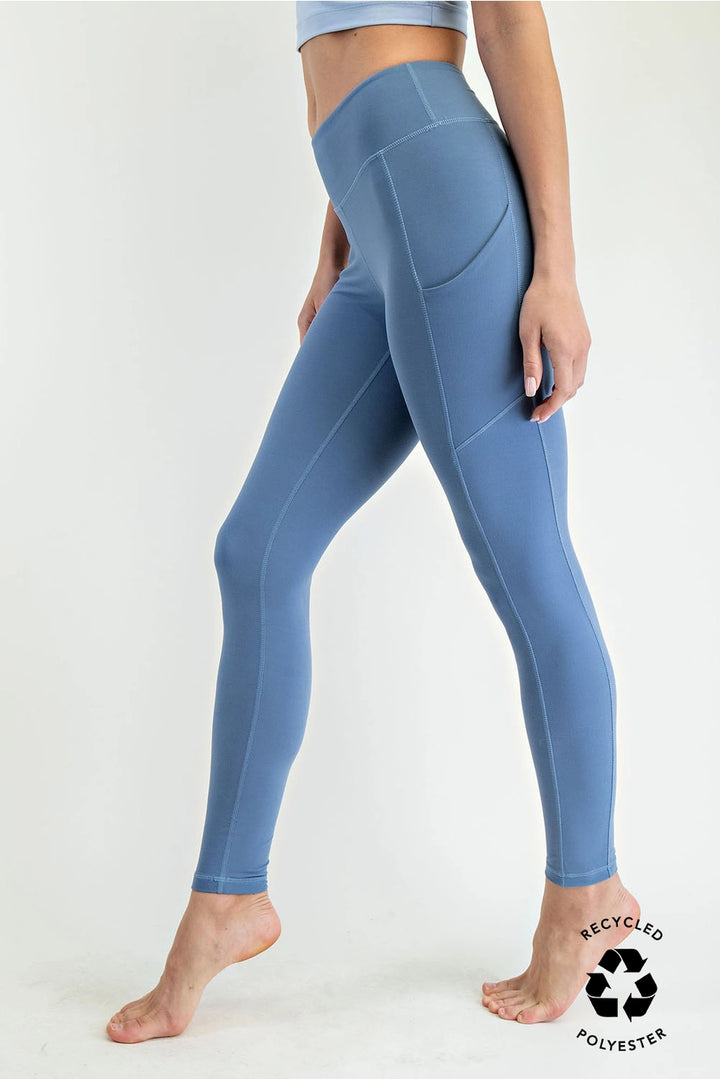 woman wearing blue leggings on plain background