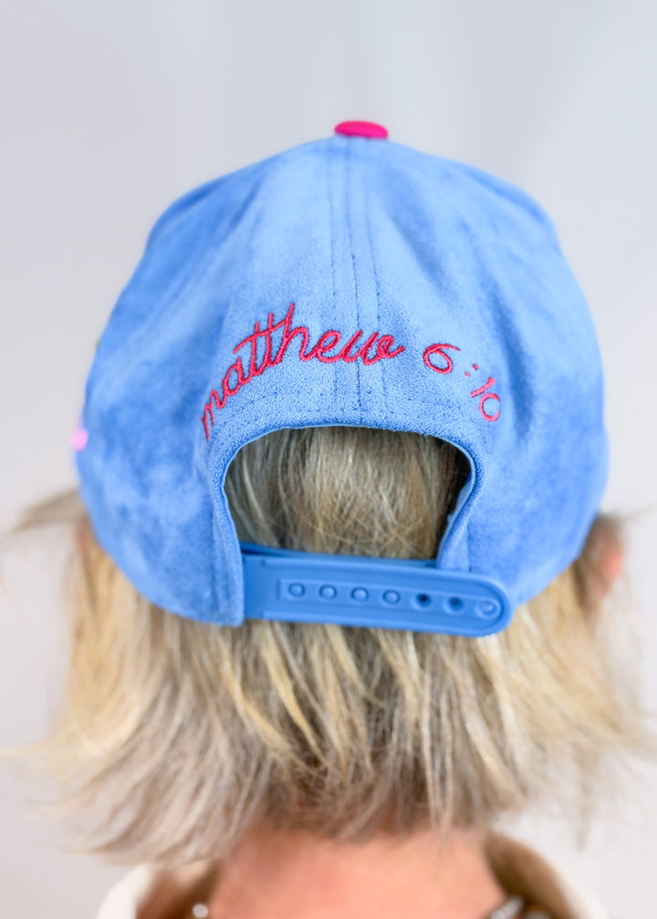 Woman shown from back wearing blue suede hat with &