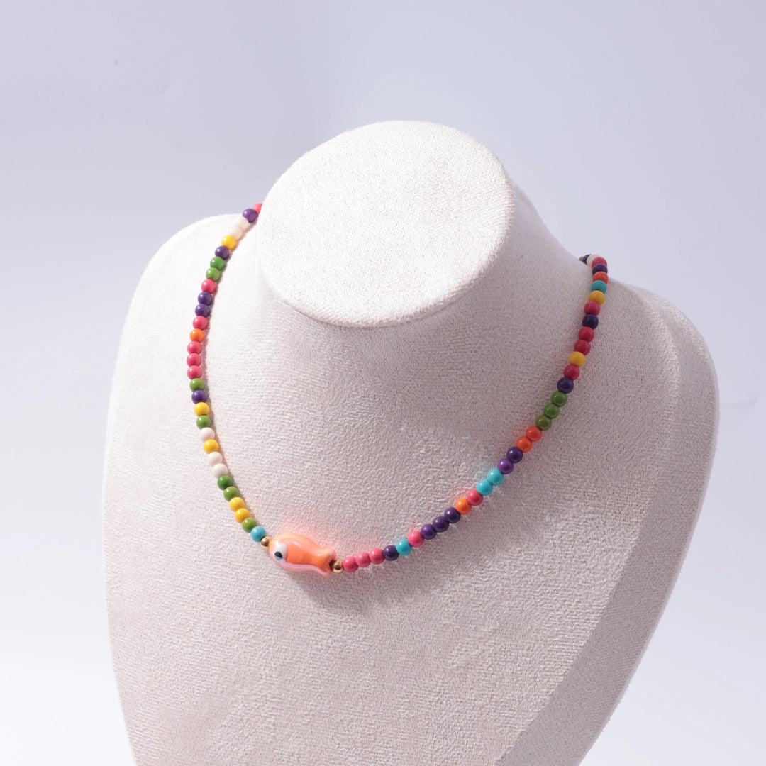 Colorful beaded necklace on a mannequin bust against a light gray background