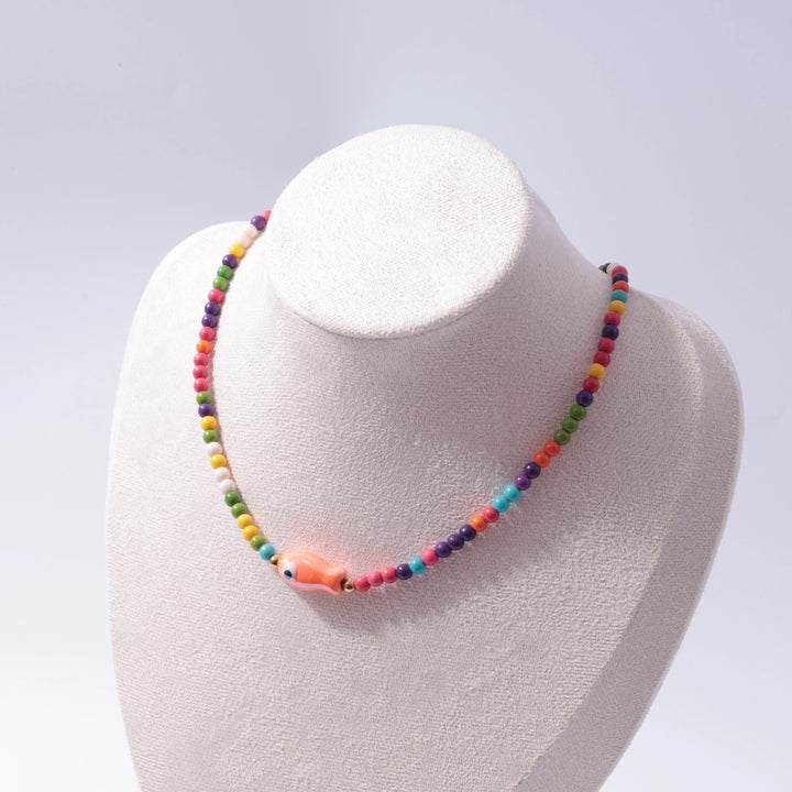 Colorful beaded necklace on a mannequin bust against a light gray background