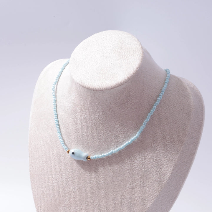 Light blue beaded necklace on a mannequin bust against a light gray background